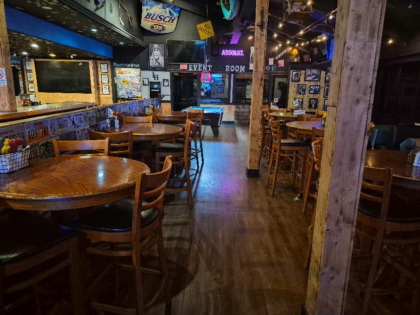 Canton Icehouse interior with wooden tables, bar seating and the event room in the background